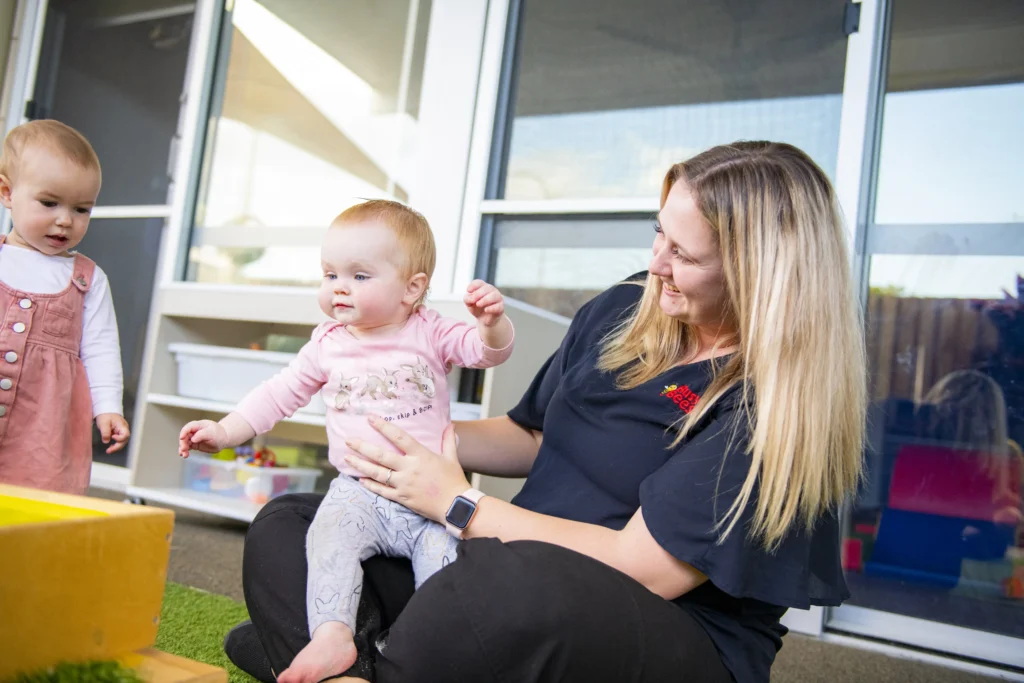 Early Childhood Educator holding a baby