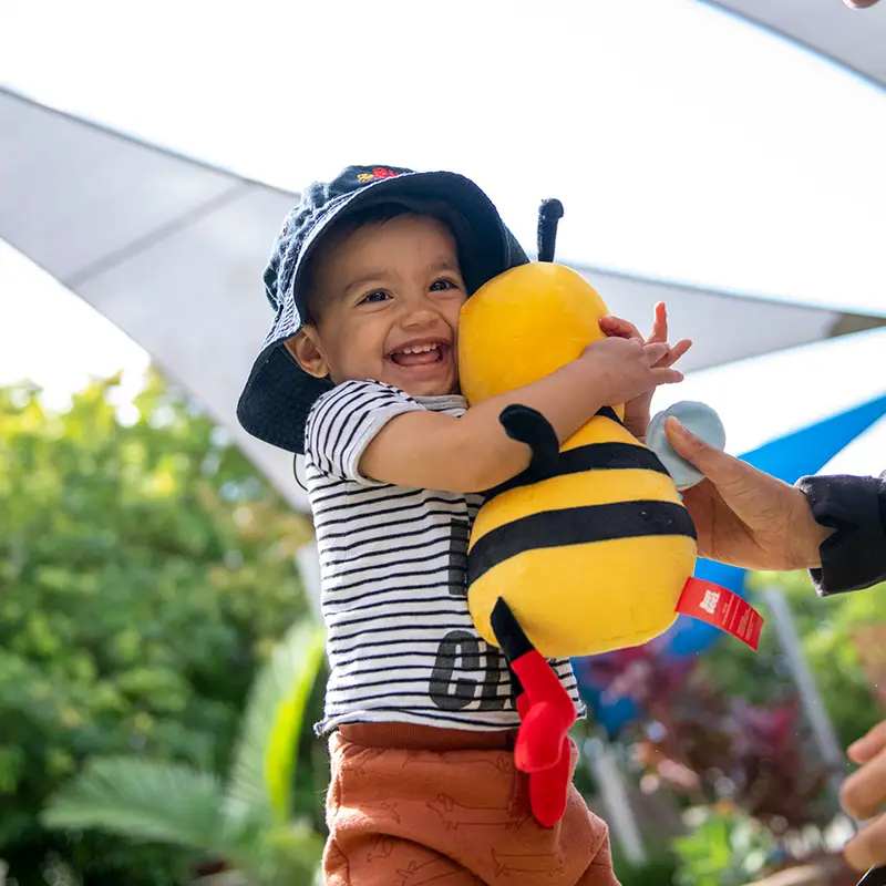 Preschool child cuddling bee soft toy