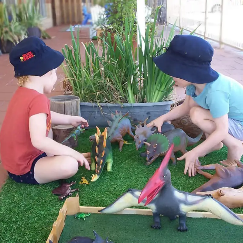 two preschool children playing with dinosaurs