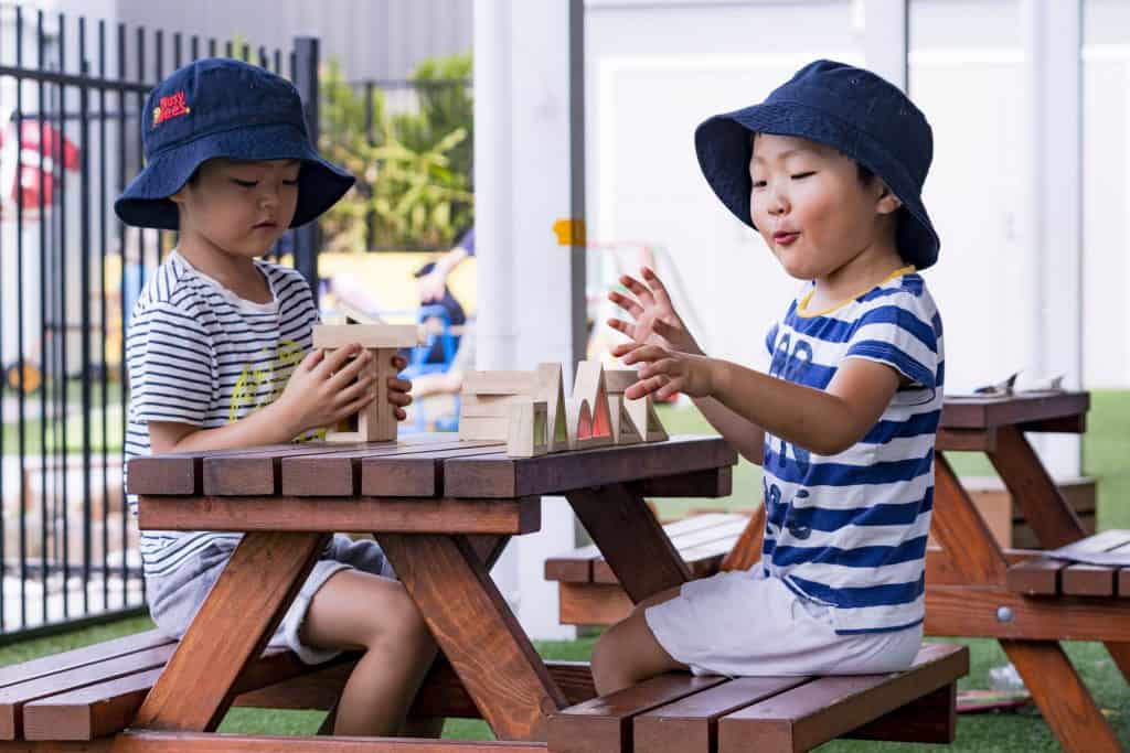 preschool children sitting at outside table