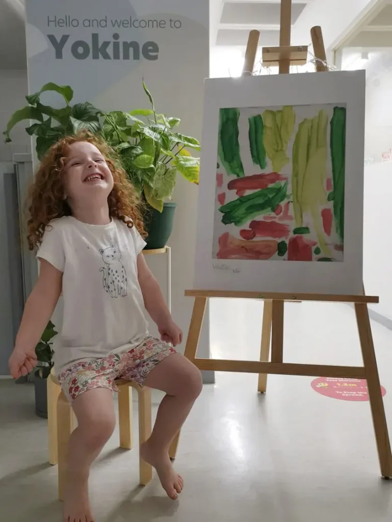 Kindergarten girl smiling with her artwork