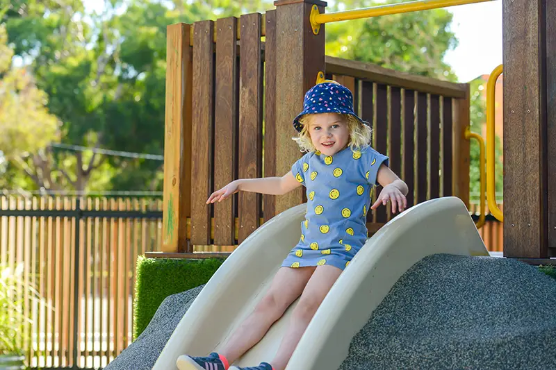 Girl on playground slide at Busy Bees at Sandringham