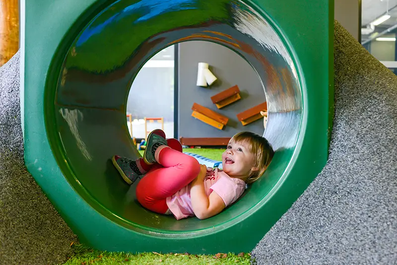 A child inside a playground tunnel