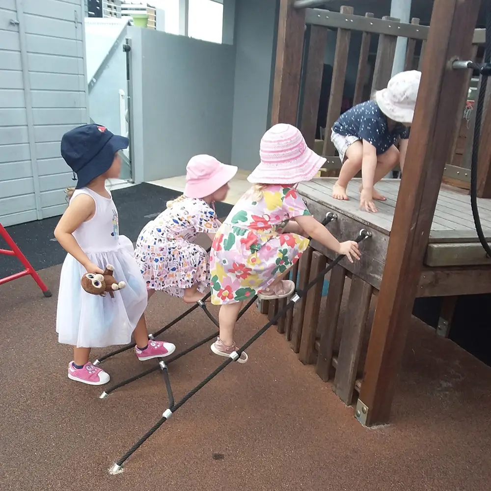 Children climbing on playground equipment at Woolloongabba East child care centre