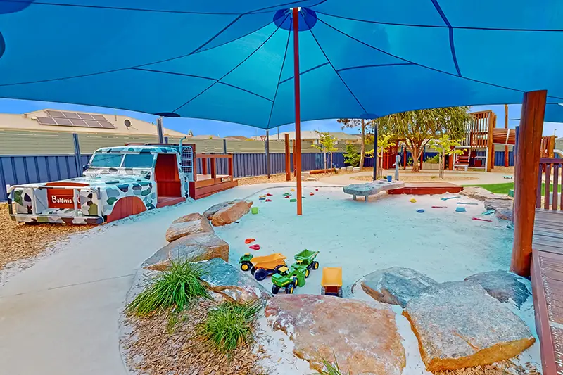 shaded outdoor playground with sandpit