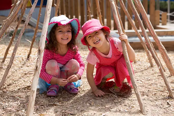 two girls in wooden teepee