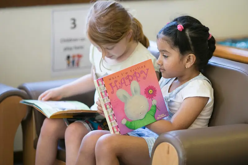 two young girls reading books
