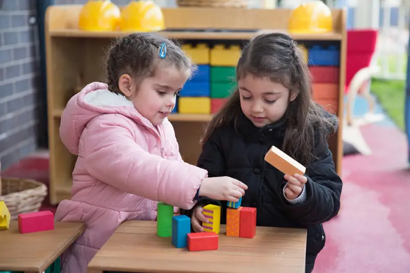 Preschool girls playing with blocks