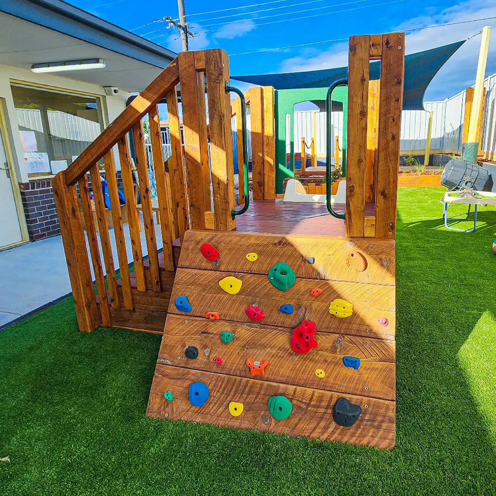 Timber fort with rock climbing ramp located in the playground at Glenroy preschool