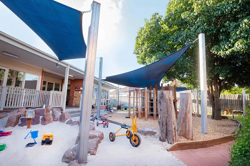 Playground at Busy Bees at Preston East with sandpit, bike track and climbing equipment.