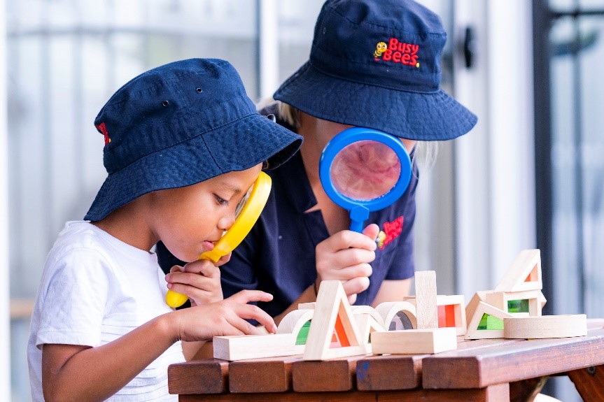 A child and Busy Bees Educator looking studying different shapes