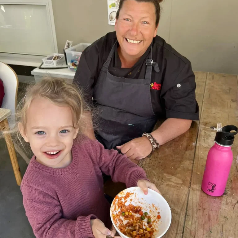 Chef Maxi with preschool girl eating Spanish meatball dish