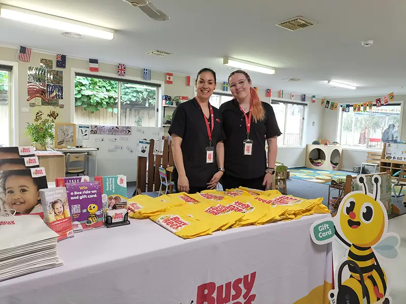 Busy Bees Educators standing behind event table