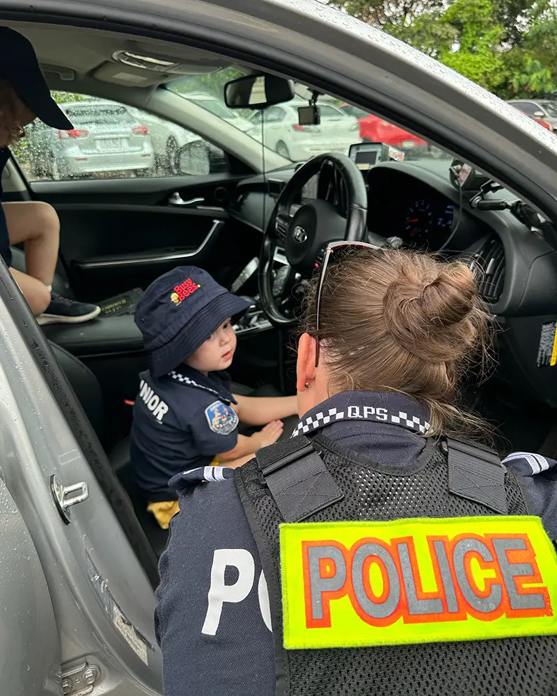 Child sitting inside police car