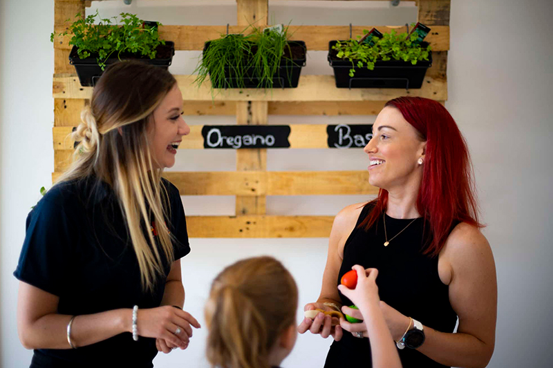 Two Early childhood educators looking at each other and smiling