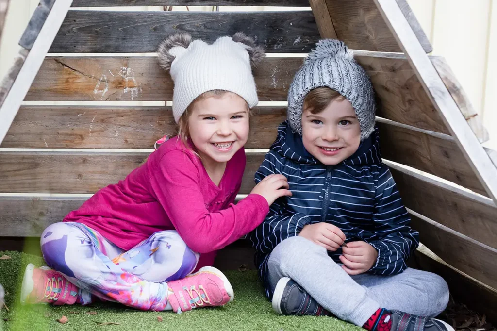 Young girls and boy in warm winter clothes