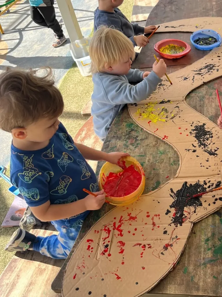 Children painting rainbow serpent at Cameron Park childcare