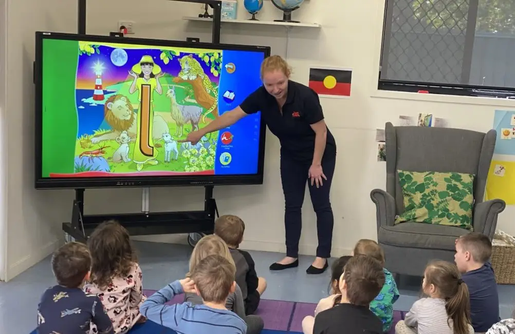 Early Childhood Teacher pointing at interactive screen