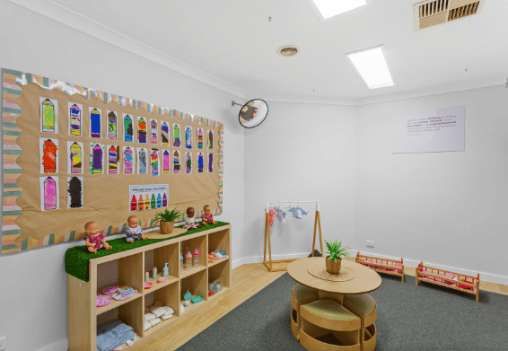 Learning area with children's artwork, shelving and educational resources
