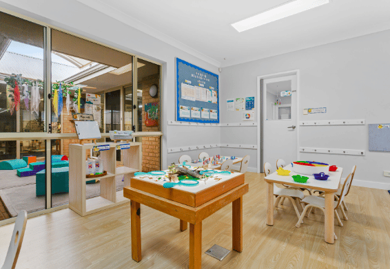 Classroom learning area with activity table and educational resources.
