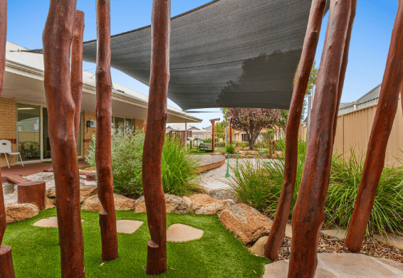 Natural outdoor play area with timber posts, pathways and garden landscaping.