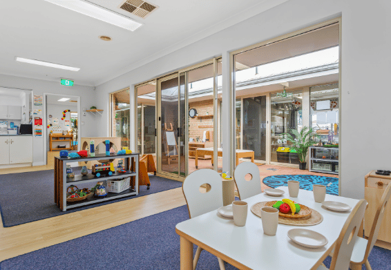 Classroom with activity table overlooking outdoor learning spaces.