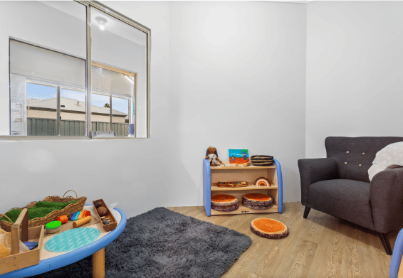 Small learning nook with educational resources and soft furnishings.