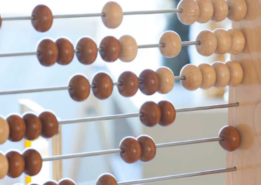 Close-up of a wooden abacus with brown and beige beads on metal rods, a perfect tool for early learning in any day care setting.