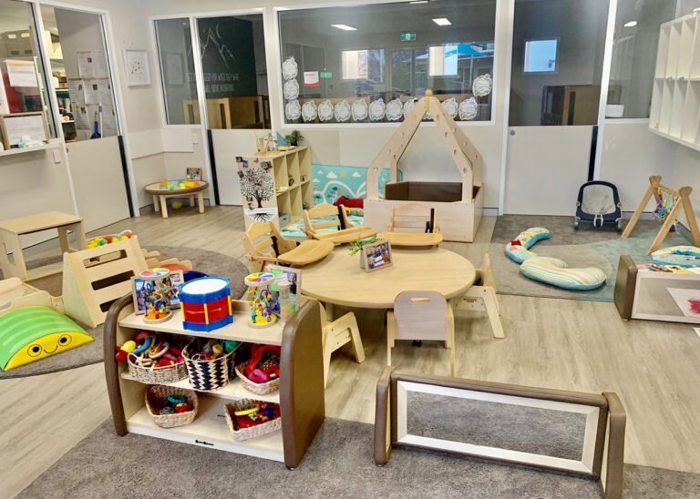 A well-organized daycare room with educational toys, small furniture, activity stations, and colorful decorations arranged neatly offers an ideal environment for childcare.