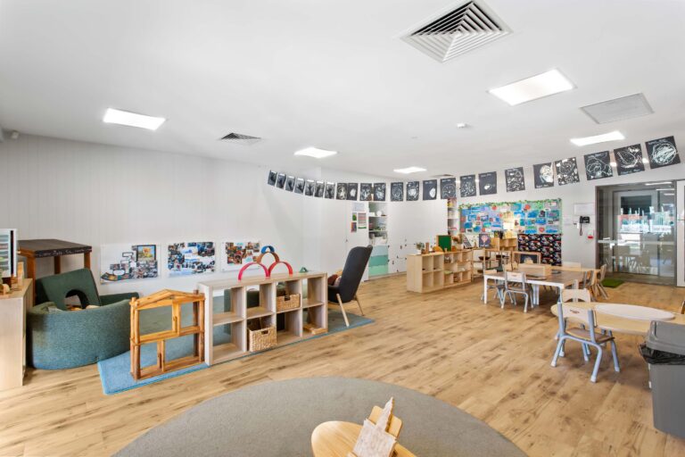 Kindergarten room at Busy Bees Aveley with a space themed display wall and a quiet reading corner