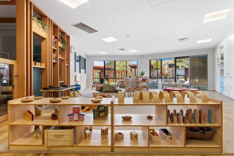 Learning room at Busy Bees Aveley with a loose parts shelf and windows onto the playground