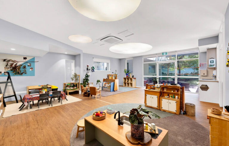Kindergarten room at Busy Bees Glenroy Station with a nature display, home corner and garden views