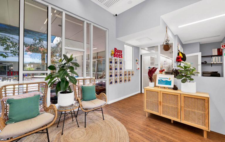 Reception at Busy Bees at Glenroy Station with rattan seating and an educator photo wall